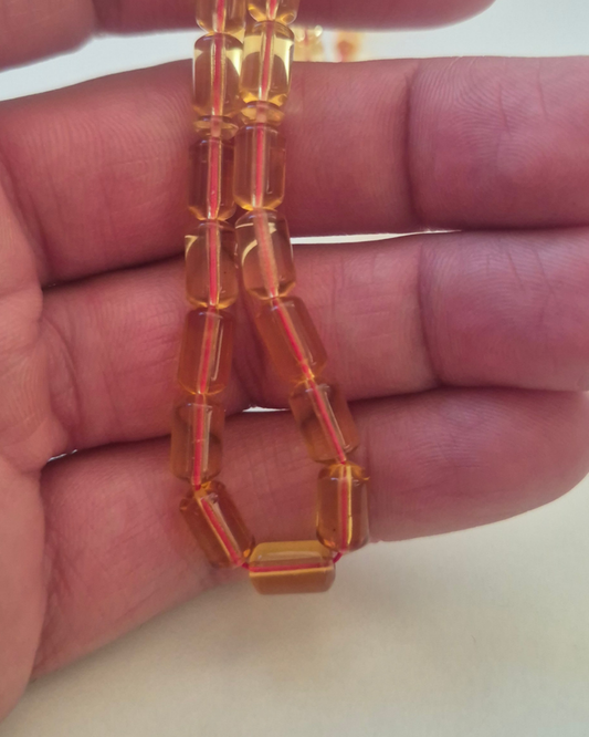 Bal Kehribar Tesbih — 9.5×5.5 mm fıçı kesim, 33 tane, sistem ve ip püsküllü · Doğal Baltık damla kehribarı — ek görünüm
